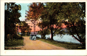An Old Car Driving Down A Dirt Path By The River, Vintage Post Card
